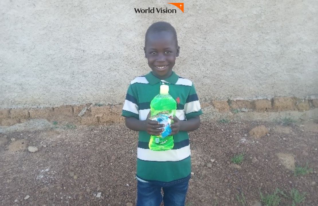 선물받은 세제를 손에들고 미소짓는 말리 아동
