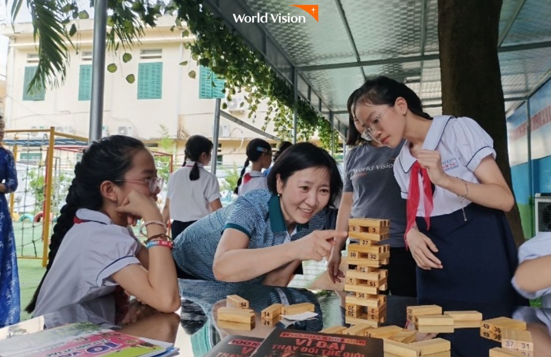 새로 지어진 야외 도서관에서 블록놀이하는 선생님과 베트남 학생들
