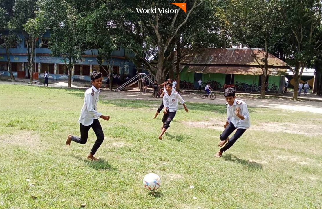 넓은 잔디밭에서 축구공으로 축구하며 노는 아이들