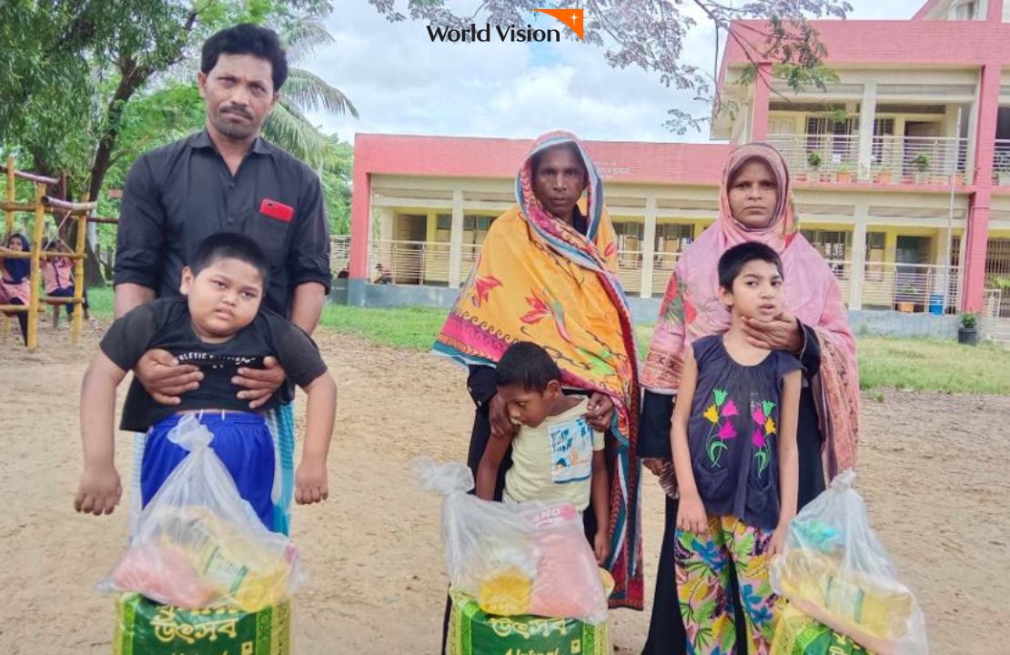 전달받은 식료품 선물과 함께 사진을 찍는 아이들과 부모님