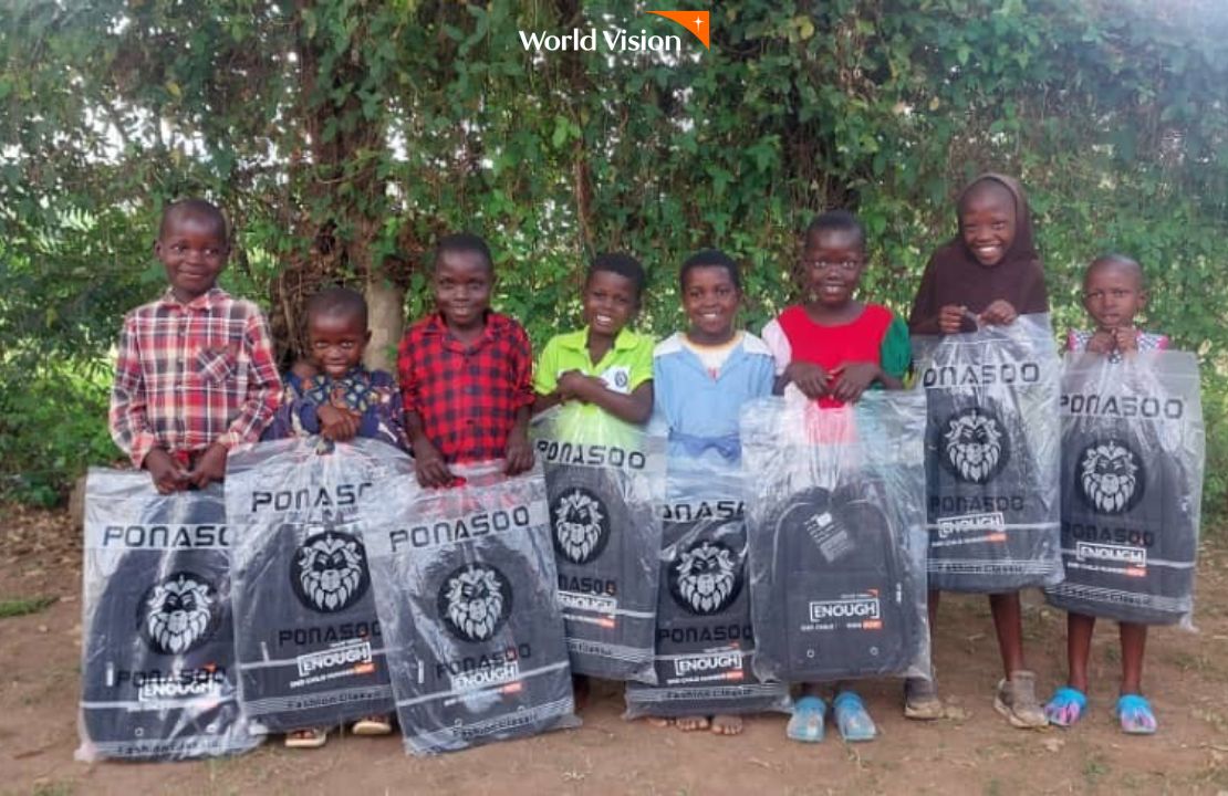 선물받은 책가방을 보여주며 사진 찍는 아이들